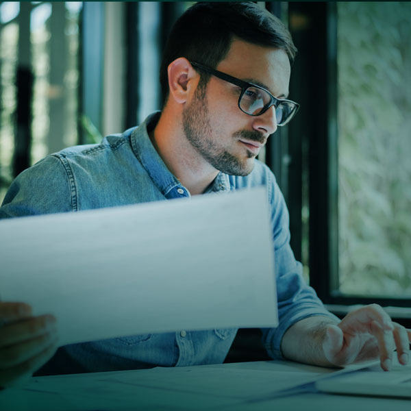 Mies käymässä paperitöitä läpi