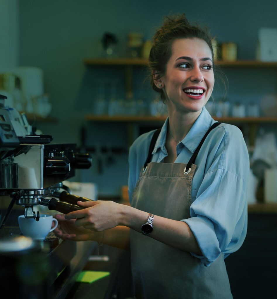 Woman at work in a café, making coffee