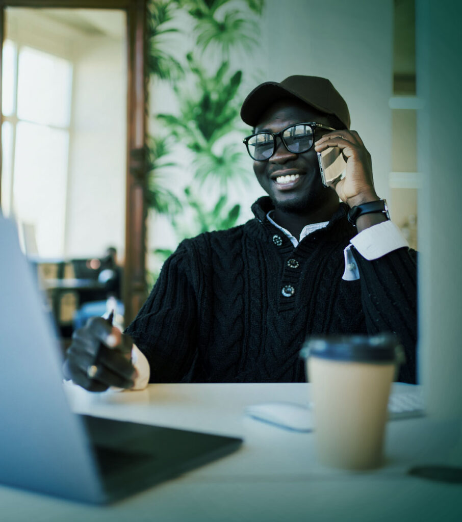 A man talking on the phone and looking at his computer