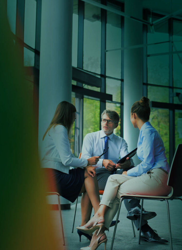 Mötesbild med tre personer som sitter ner